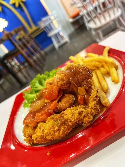 Crispy fried chicken chop with sauce and fries on a red tray